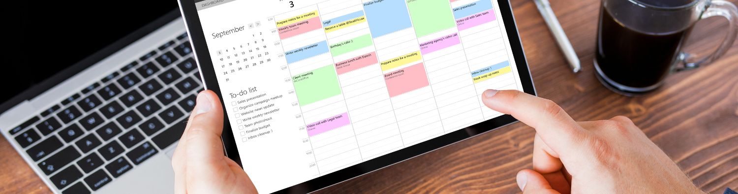 Digital calendar displayed on a tablet with a to-do list, surrounded by a laptop, coffee, and pen.