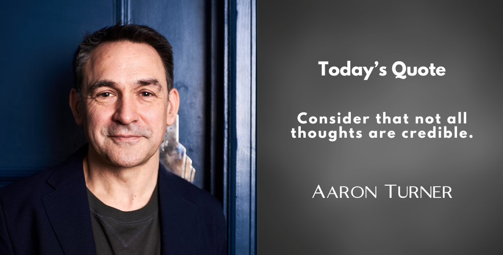 A portrait of Aaron Turner standing against a deep blue door, smiling subtly. To the right, a quote reads, "Consider that not all thoughts are credible." Below, his name is displayed in white text.