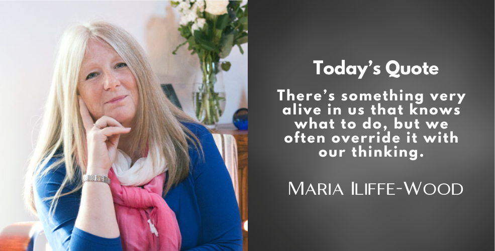 Portrait of Maria Iliffe-Wood smiling gently, seated in a well-lit room with flowers in the background. A quote is displayed beside her on a dark grey background.