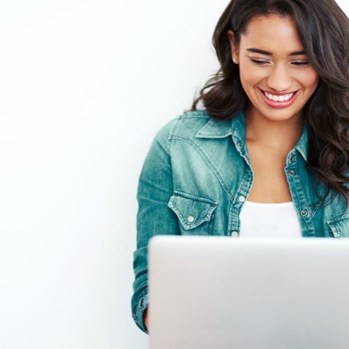 Woman smiling while working on laptop — Simplified Blogging Solution™